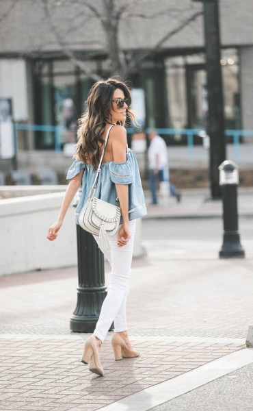 A denim off-the-shoulder top with slim jeans, a saddle bag, and suede pumps